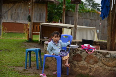 Full length of girl sitting on chair