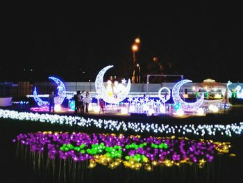 Illuminated lights against clear sky at night