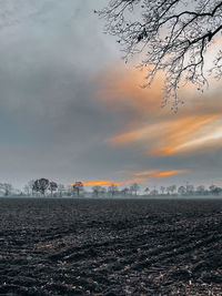 Scenic view of snowy field against sky during sunset