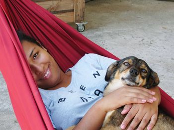 Portrait of woman and dog relaxing in hammock