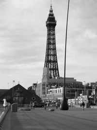 People walking on road against tower