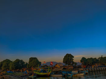 Boats moored in swimming pool against blue sky