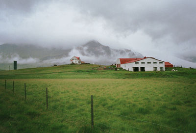 Scenic view of grassy field against cloudy sky