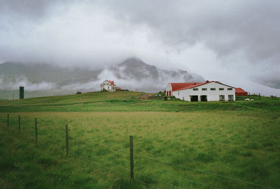 Scenic view of grassy field against cloudy sky