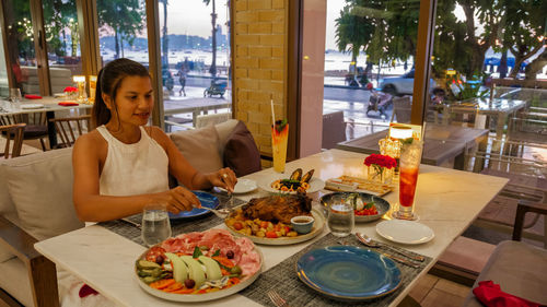 Midsection of woman having food at restaurant