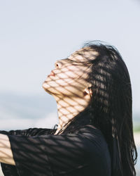 Close-up of young woman against clear sky