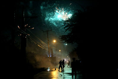 Silhouette people on road at night