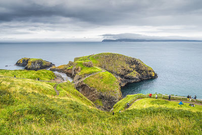 Tourists sightseeing the carrick a rede rope bridge, northern ireland