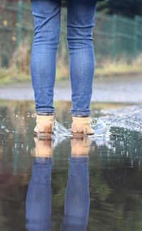 Low section of man standing on wet glass