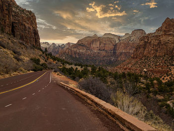 Road leading towards mountains against sky
