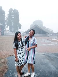 Full length of a smiling young woman standing on mountain