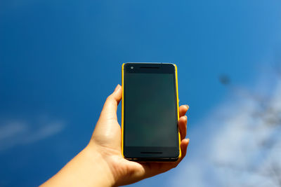 Cropped hand holding mobile phone