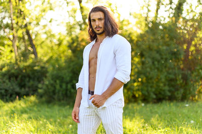 Portrait of man standing against plants in park