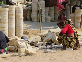 Rear view of women sitting by stones on field