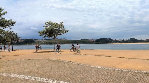 People at beach against sky