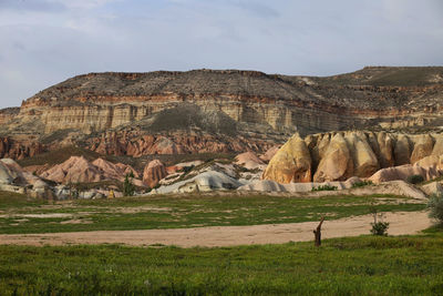 Rock formations on field against sky