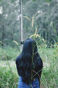 Rear view of woman standing on field
