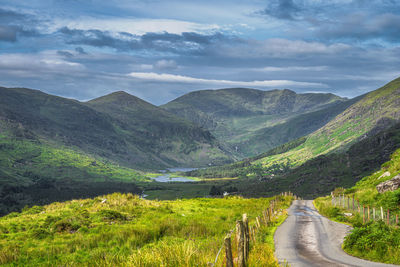 Road leading towards mountains against sky