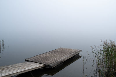 Pier over lake against sky