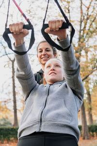 Friends exercising in park amidst trees during autumn