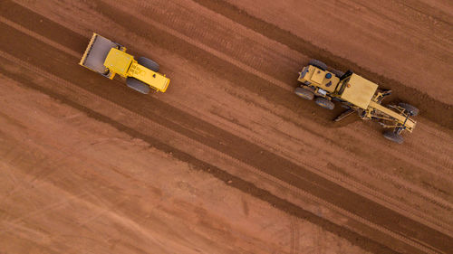 Aerial view yellow excavator building a highway, road grader heavy earth moving, bulldozer working