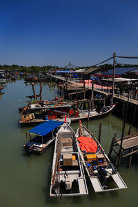 Boats moored in water against clear sky