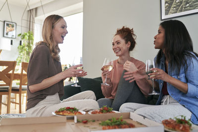 Female friends using mobile phone at home