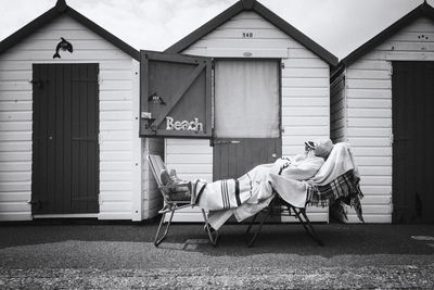 View of man on chair against built structure