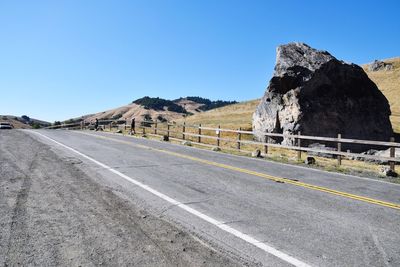 Road by mountain against clear sky