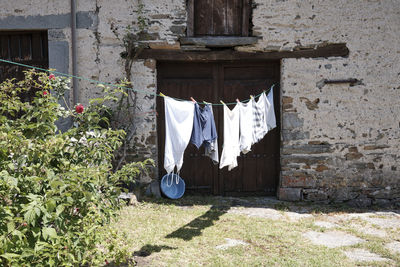 Laundry drying on a clothesline against country house