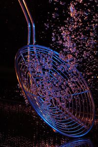 Close-up of skimmer with bubbles in water against black background