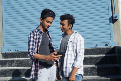 Portrait of young man standing against wall