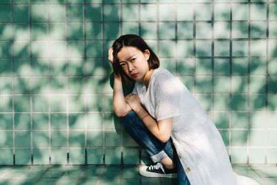 Side view of a young woman sitting outdoors