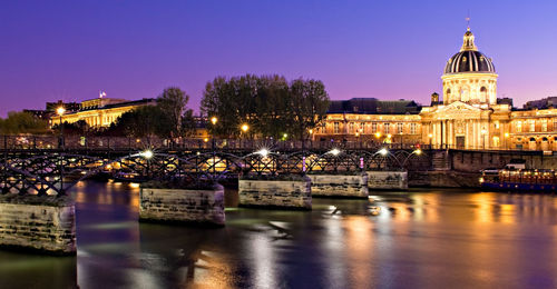 Illuminated buildings against sky during sunset