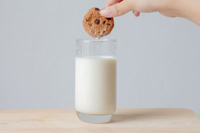 Midsection of person holding drink on table