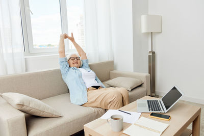 Young woman using laptop on bed at home