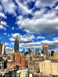 Modern cityscape against cloudy sky