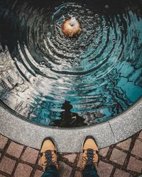 Low section of person standing by swimming pool