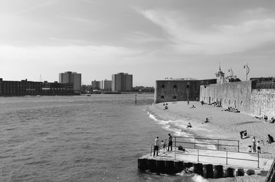 Scenic view of sea by buildings against sky