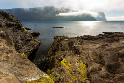 Scenic view of rocks in sea against sky