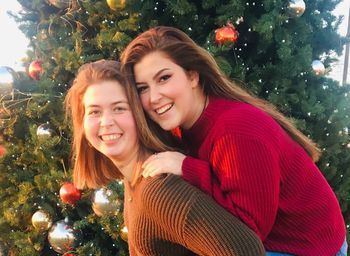 Portrait of a smiling young woman with christmas tree