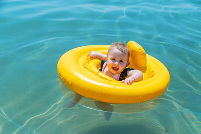 Portrait of girl with inflatable ring swimming in pool