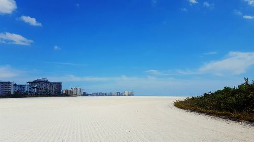 Scenic view of beach against blue sky