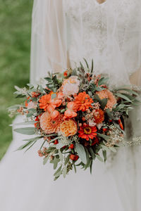 Close-up of bride holding flower bouquet