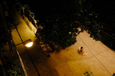 High angle view of people sitting on street at night