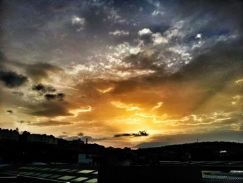 Silhouette of built structure against cloudy sky at sunset