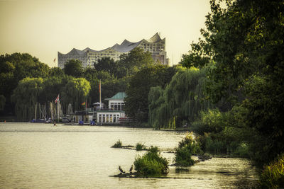 River amidst trees and buildings against sky