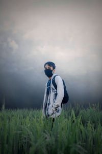 Man standing on field against sky