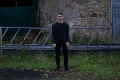 Portrait of teenage girl standing against brick wall
