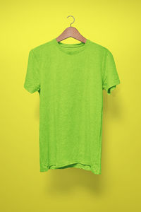 Green paper hanging against yellow wall